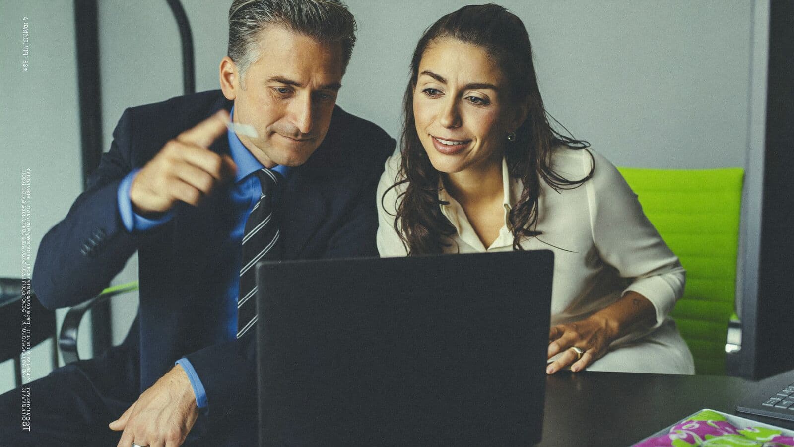 Two colleagues testing software together at a laptop