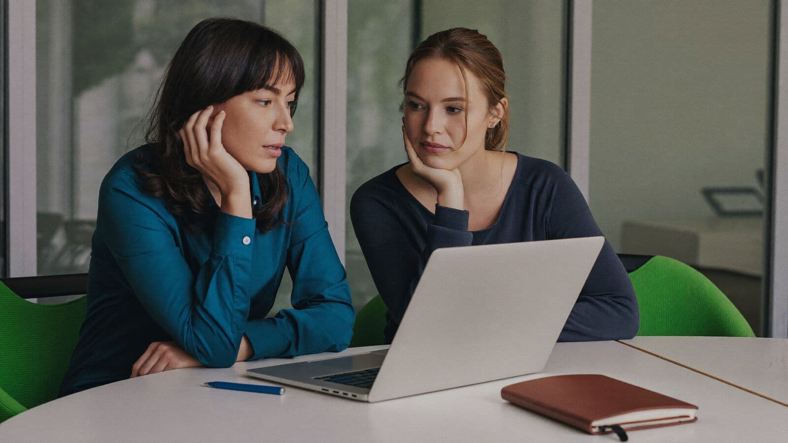 Two colleagues discussing a readiness checklist at a laptop