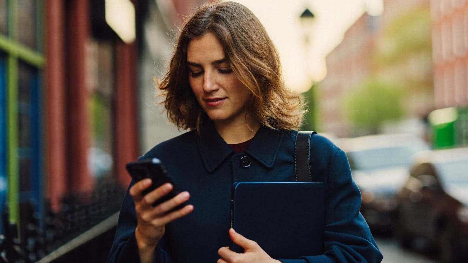 Professional checking an appointment reminder on her phone on a city street